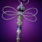 Purple-themed handmade dragonfly ornament photographed on a solid background